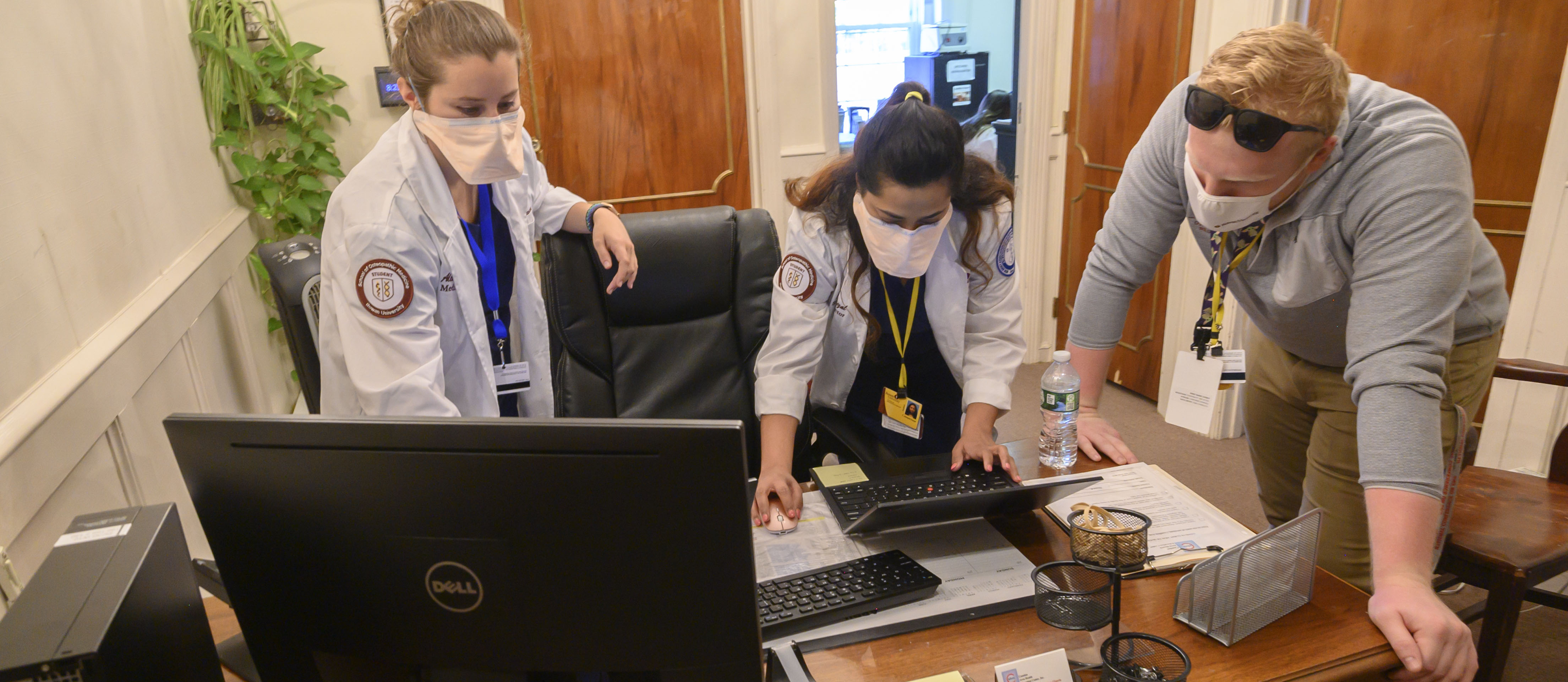 Rowan Medicine employees work at a computer